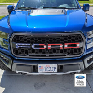 blue Ford Raptor truck with American flag in Ford logo